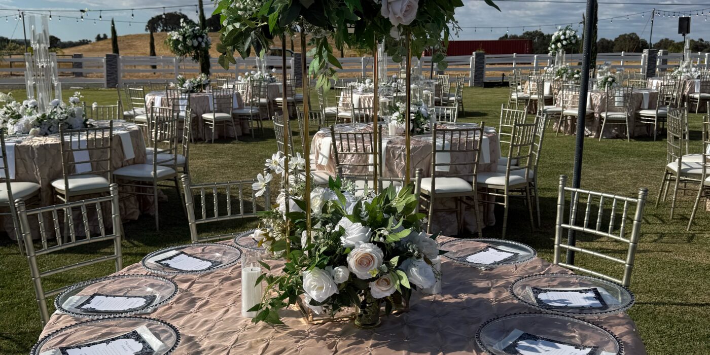 Outdoor reception set with linens, chargers and floral centrepieces